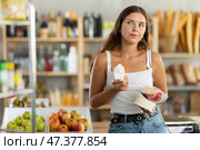 Young femsle shopper selects delicious cheese in supermarket. Стоковое фото, фотограф Яков Филимонов / Фотобанк Лори