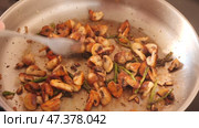 There is frying pan with pieces of champignons and green asparagus shoots on gas stove. Home cooking of delicious dishes according to recipes of cookbook. Стоковое видео, видеограф Яков Филимонов / Фотобанк Лори