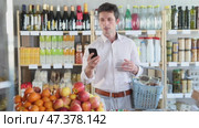 While shopping, male customer answers video call. Стоковое видео, видеограф Яков Филимонов / Фотобанк Лори