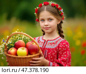 A little girl in a Russian sarafan with a basket of fresh ripe apples. August 19 – Transfiguration of the Lord, or Apple Savior – one of the first harvest holidays; the day from which, according to legend, nature moved from summer to autumn and winter. Стоковое AI-изображение, AI-художник Сергей Елизарьев / Фотобанк Лори