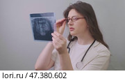 Dentist conducts a thorough examination, comparing X-rays to detect hidden dental issues and diagnose accurately. Стоковое видео, видеограф Svetlana Golovco / Фотобанк Лори