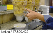 A child's hand pours cornflakes into a breakfast plate on an all-inclusive buffet in the hotel restaurant, turns the dispenser valve. Стоковое видео, видеограф Ольга Симонова / Фотобанк Лори