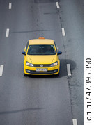 Taxi car rushes down a wide city street. Yellow sedan in motion on highway, above front view. Редакционное фото, фотограф Константин Григорьев / Фотобанк Лори