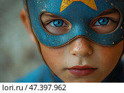 A close-up of a child's face in a superhero costume. The child wears a blue mask with a gold star, through the holes of which brightly sparkle blue eyes, full of determination and strength. The skin is covered with light freckles, the lips are slightly pursed - the facial expression is focused and confident. The atmosphere of the photo is inspiring, emphasizing the inner strength, dream and imagination inherent in childhood. The light is soft and warm, the texture of the mask emphasizes its slightly aged, realistic look. Стоковое AI-изображение, AI-художник Анна Кривицкая / Фотобанк Лори