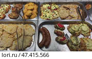 Cooked fish, breaded cutlets and chicken breasts resting in metal trays, ready to be served. Стоковое видео, видеограф Mikhail Davidovich / Фотобанк Лори