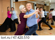Ederly couple enjoying slow foxtrot in dance studio. Стоковое фото, фотограф Яков Филимонов / Фотобанк Лори