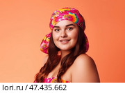 Happy woman in headscarf on orange background, chubby plus size model portrait. Стоковое AI-изображение, AI-художник Станислав Тарко / Фотобанк Лори