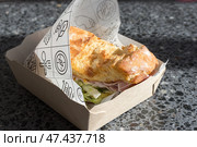 Сэндвич с вкуснейшим свежим хлебом с хрустящей корочкой и ветчиной в оберточной бумаге и картонном подносе, купленный на фуд-корте. Стоковое фото, фотограф Татьяна Васильева / Фотобанк Лори