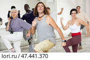 Caucasian man rehearsing modern dance with group in dance school. Стоковое фото, фотограф Яков Филимонов / Фотобанк Лори