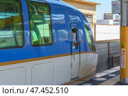 Osaka, Japan - Sep 26 2024, view of the driver's cabin of an intercity electric train standing on the railway platform, with living buildings on background, without people, at daytime, Osaka, Japan. Редакционное фото, фотограф Сергей Богомяко / Фотобанк Лори