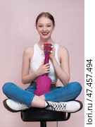 Cheerful musician with ukulele held upright, sitting on bar stool, looking camera with toothy smile. Стоковое фото, фотограф А. А. Пирагис / Фотобанк Лори