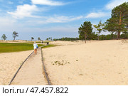 BAIKAL LAKE, OLKHON ISLAND, KHUZHIR VILLAGE, IRKUTSK REGION, RUSSIA - August 03, 2024: Tourists walk on ecological wooden trail to popular sandy beach of Sarayskiy Bay on summer sunny day. Редакционное фото, фотограф Виктория Катьянова / Фотобанк Лори