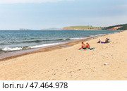 BAIKAL LAKE, OLKHON ISLAND, KHUZHIR VILLAGE, IRKUTSK REGION, RUSSIA - August 03, 2024: People relax and sunbathe on the sandy beach of Saraiskiy Bay on a summer sunny day. Редакционное фото, фотограф Виктория Катьянова / Фотобанк Лори