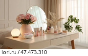 Decorative vanity table with skincare products and floral arrangement. Декоративный туалетный столик со средствами по уходу за кожей и цветочной композицией. Стоковое AI-изображение, AI-художник Katsiaryna Repich / Фотобанк Лори