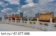 The terrace of the Chinese temple is paved and fenced with white carved stone railings. There are tiled roofs of pagodas behind the fence. Lanterns along the curved edges of the cornices. Malaysia. (2023 год). Стоковое фото, фотограф Вера Ивановна Кубарева / Фотобанк Лори