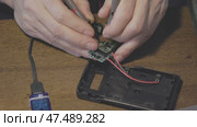 Hands Skillfully Repairing an Electronic Circuit Board Using a Multimeter for Testing. Стоковое видео, видеограф Olesia Kondrateva / Фотобанк Лори