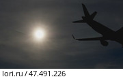 Airplanes silhouetted against golden sunset, landing with dramatic backlighting, soft airport horizon glowing during twilight descent. Стоковое видео, видеограф Данил Руденко / Фотобанк Лори