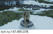 Nordic clad blonde woman wandering snow covered mountain slopes, capturing serene winter wilderness atmosphere in Pyrenees National Park landscape. Стоковое видео, видеограф Данил Руденко / Фотобанк Лори