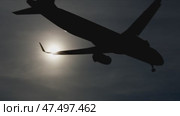 Dark airplane silhouettes descending against glowing sunset sky, highlighting striking contrast between aircraft outlines and warm golden illumination, capturing dramatic aviation moment. Стоковое видео, видеограф Данил Руденко / Фотобанк Лори