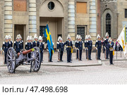 STOCKHOLM, SWEDEN - APRIL 30, 2018: The Royal Guard with flags and an old cannon at the celebration of King Carl XVI Gustaf's 72nd birthday at the Royal Palace in Stockholm. Редакционное фото, фотограф Сергей Комаров / Фотобанк Лори