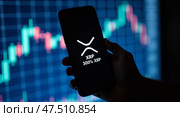 Xrp cryptocurrency trading and market growth displayed on smartphone. Редакционное AI-изображение, AI-художник Андрей Бакусов / Фотобанк Лори