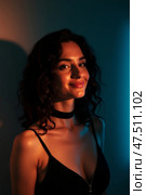 Elegant woman with dark wavy hair in dramatic lighting. Стоковое AI-изображение, AI-художник Андрей Бакусов / Фотобанк Лори