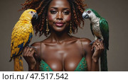 A woman is holding two parrots, one yellow and one green. Стоковое AI-видео, аниматор Виктория Кольцова / Фотобанк Лори