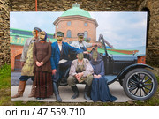 Тантамареска с изображением большой компании в старинной одежде возле ретро автомобиля. Стенд для фотосъёмки с отверстием для лица (2024 год). Редакционное фото, фотограф Pukhov K / Фотобанк Лори