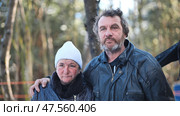 Homeless couple battling alcohol addiction, surviving winter hardships among bare forest trees, depicting raw urban struggle. Стоковое фото, фотограф Mikhail Davidovich / Фотобанк Лори