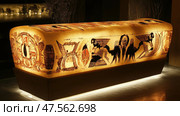 Illuminated sarcophagus showing ancient egyptian drawings in modern setting. Стоковое AI-изображение, AI-художник Юрий Поздников / Фотобанк Лори