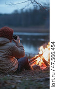 Hiker drinking by the bonfire at dusk. Стоковое AI-видео, аниматор Юрий Поздников / Фотобанк Лори
