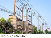 Power transmission line infrastructure with electrical transformers and cables laid along a row of poles against a sky background. Стоковое фото, фотограф Коханова Наталья / Фотобанк Лори