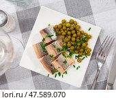 Sliced herring served with scallion and peas on table. Стоковое фото, фотограф Яков Филимонов / Фотобанк Лори