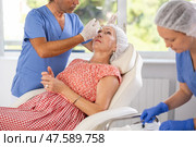 Senior woman undergoing botulinum injections at aesthetic medicine clinic. Стоковое фото, фотограф Яков Филимонов / Фотобанк Лори