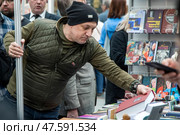 Писатель Захар Прилепин смотрит книги на прилавке на международной ярмарке интеллектуальной литературы Non/fiction в Гостином дворе города Москвы, Россия. Редакционное фото, фотограф Николай Винокуров / Фотобанк Лори