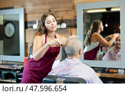 Girl master hairdresser completes creation of senior male clients image with help of scissors. Стоковое фото, фотограф Яков Филимонов / Фотобанк Лори