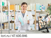 Female pharmacist recommending dermatological shampoo at pharmacy counter. Стоковое фото, фотограф Яков Филимонов / Фотобанк Лори