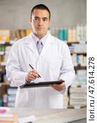 Man pharmacist makes restock, uses electronic carrier tablet. Стоковое фото, фотограф Яков Филимонов / Фотобанк Лори
