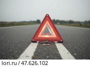 Аварийный знак красный треугольник стоит на дороге. Стоковое AI-изображение, AI-художник Наталия Ануфриева / Фотобанк Лори