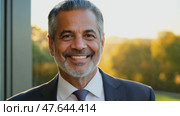 Smiling confident stylish mature middle aged man standing in modern office. Old senior businessman gray haired man 60s business executive manager looking at camera arms crossed portrait. Стоковое AI-видео, аниматор ALLA YURTAYEVA / Фотобанк Лори