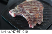 Medium rare fried entrecote beef steak in cast iron pan with salt and pepper. Стоковое видео, видеограф Яков Филимонов / Фотобанк Лори