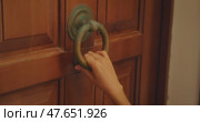 Closeup of woman hand knocking on wooden door with vintage ring knocker in Italy. Стоковое видео, видеограф Igor Tichonow / Фотобанк Лори