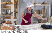 Woman baker cutting dough pieces with scraper and weighing in scales. Стоковое видео, видеограф Яков Филимонов / Фотобанк Лори