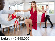 Woman dances incendiary boogie woogie with African man partner during choreography lesson. Стоковое фото, фотограф Яков Филимонов / Фотобанк Лори