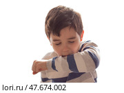 A boy sneezes or coughs into his elbow on white background. Стоковое фото, фотограф Zakharova Natasha / Фотобанк Лори