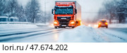 Winter transport: A heavy goods vehicle navigates a snowy road during a blizzard, design for advertisement. Стоковое AI-изображение, AI-художник Данила Большаков / Фотобанк Лори