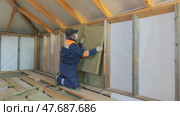 Insulation of a frame house with mineral wool. Cutting, fitting, laying insulation. Construction works. Стоковое видео, видеограф Константин Мерцалов / Фотобанк Лори