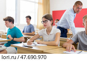 Young students sitting at desks in classroom. Стоковое фото, фотограф Яков Филимонов / Фотобанк Лори