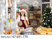 Woman seller offering sweets in decorated grocery store. Стоковое фото, фотограф Яков Филимонов / Фотобанк Лори