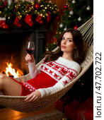 Beautiful girl with a glass of wine relaxing in a hammock. Стоковое AI-изображение, AI-художник Сергей Елизарьев / Фотобанк Лори